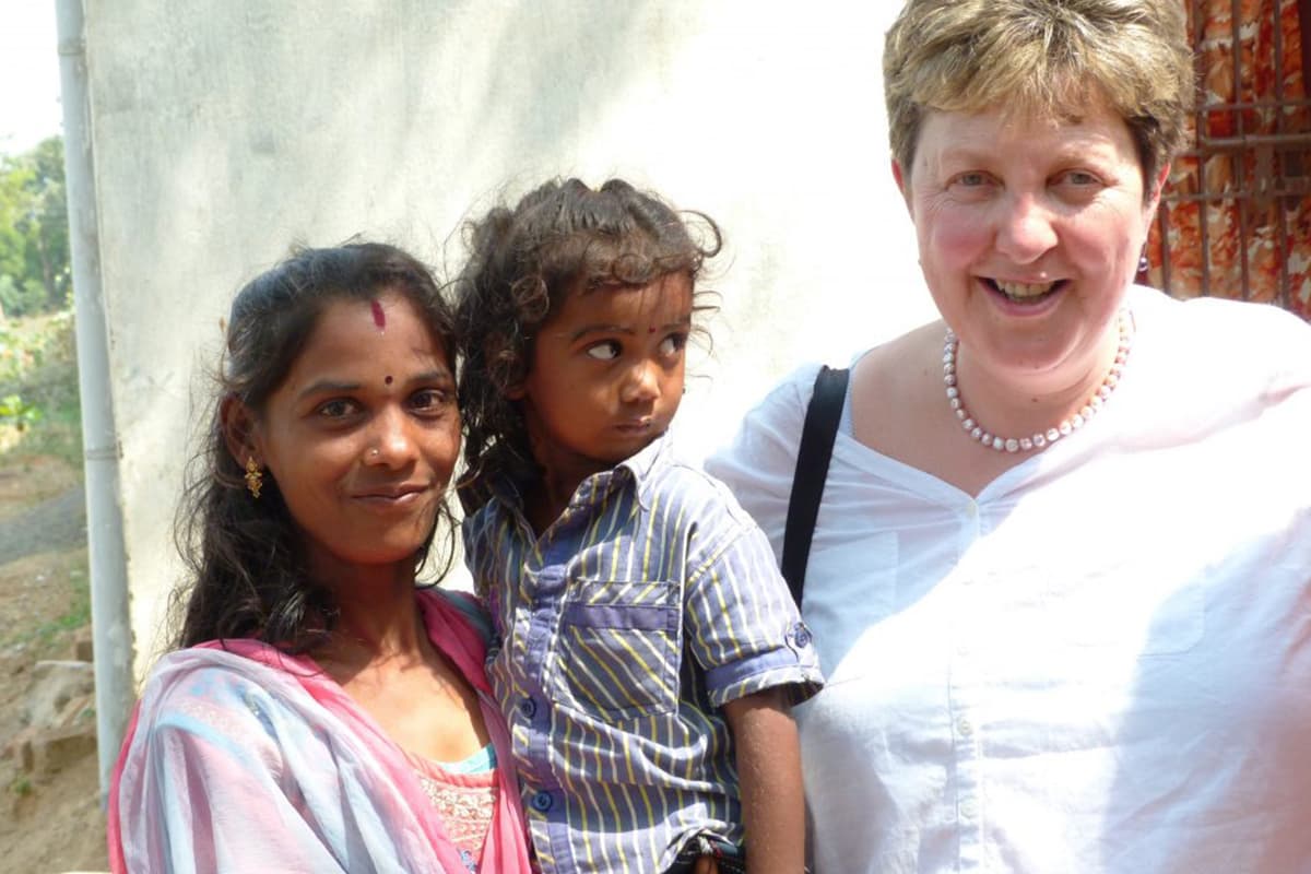 Co-Founder Jackie Elton stood beside a mother and her child