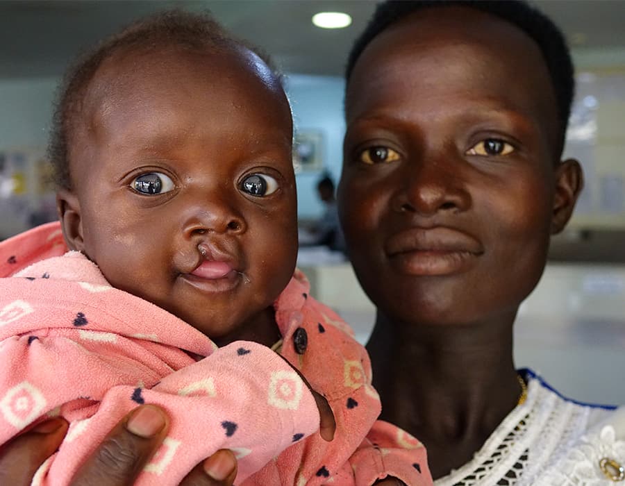 Mother holding baby in a pink shirt