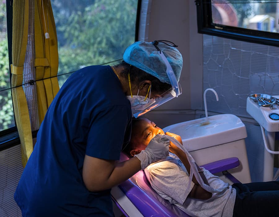 Dental hygenist working on a child sitting in a dental chair